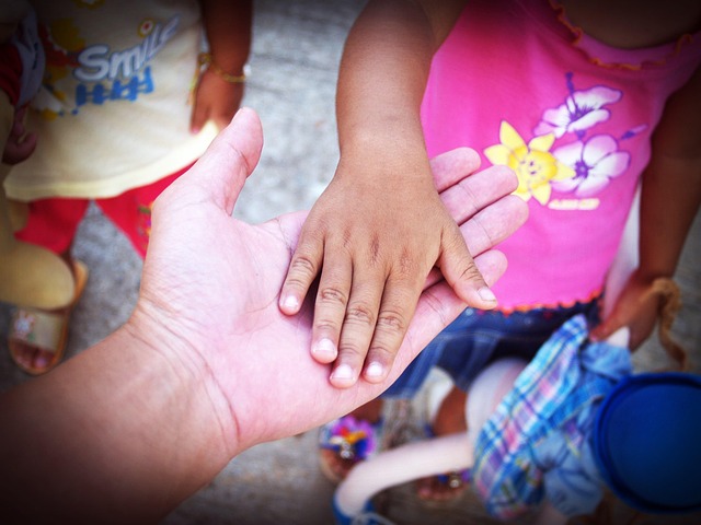 Close-up of two hands intertwined, with 'Mi Amor' written in elegant script between them. (definition mi amor)