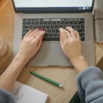 person writing on laptop blog