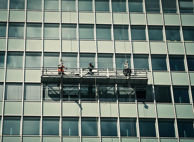window cleaner using a water-fed pole system on a multi-story building