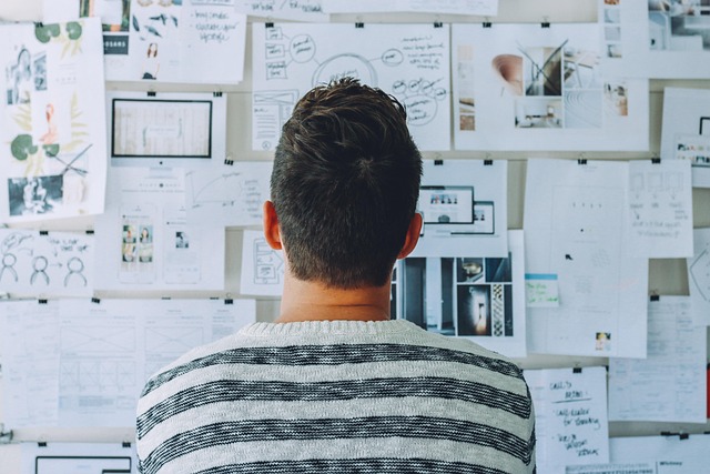 Woman brainstorming blog niche ideas at a desk with notebooks (how to start blogging for beginners)