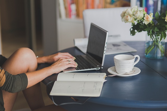 Writer typing on a laptop with a draft of a blog post on screen