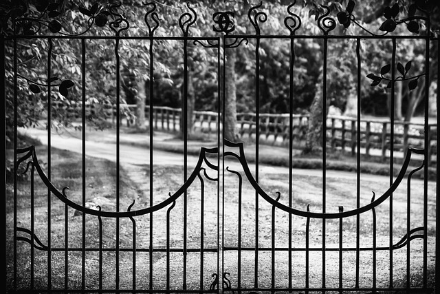 A black wrought iron outdoor bench with intricate scrollwork, placed on a stone patio.