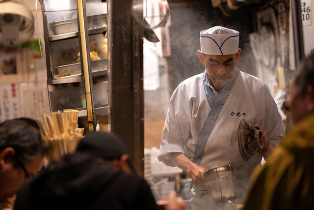 A chef carefully garnishing a bowl of soup du jour with fresh herbs. (Soup of the Day)
