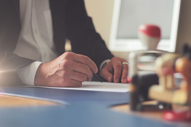 Close-up of a business person reviewing financial statements and using a calculator