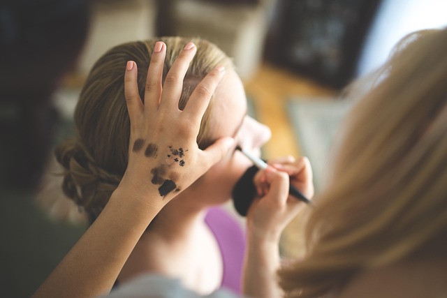 Close-up of makeup artist's hands holding brushes and product palettes (lori anne allison makeup artist)
