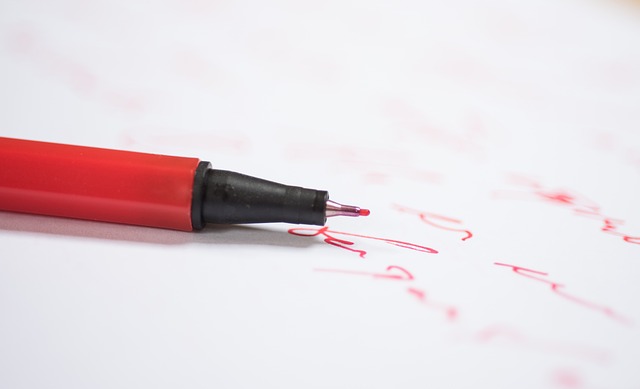 Close-up of a pen hovering over a document, symbolizing focused effort and decision-making (dedicated synonym)