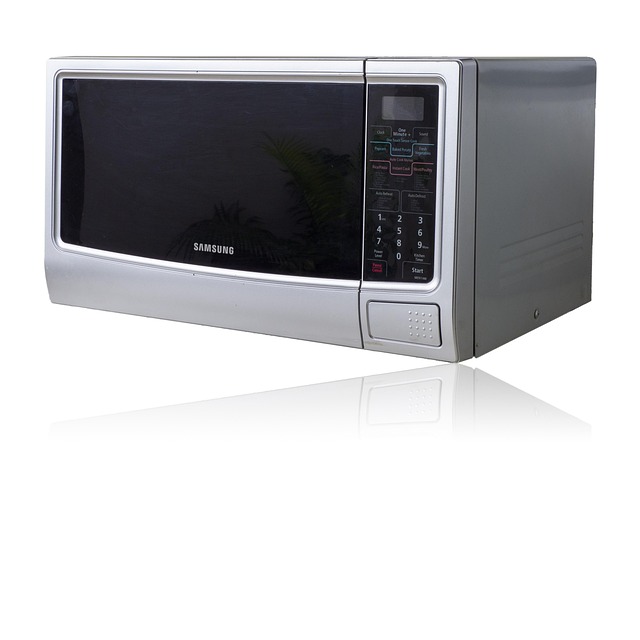 Microwave oven repair technician using a multimeter to test a component