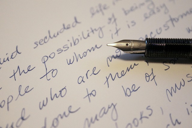 A person writing in a journal with a thoughtful expression